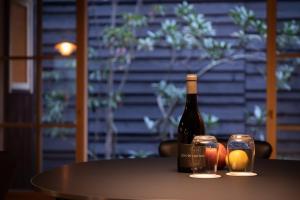 大津的住宿－Hotel Koo Otsuhyakucho，桌子上放有一瓶葡萄酒和两杯酒