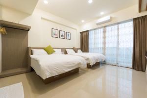 um quarto com 2 camas e uma janela em Jerry B&B em Taitung City