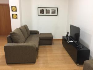 a living room filled with furniture and a tv at Invicta House Avenida da Boavista in Porto
