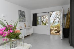 a white living room with a table and a mirror at Surfing Beach Village Paros in Santa Maria