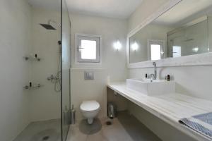 a bathroom with a sink and a toilet and a shower at Surfing Beach Village Paros in Santa Maria