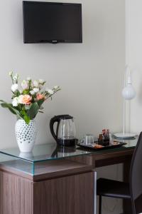 a desk with a vase with flowers on it at Rhome Suites in Rome