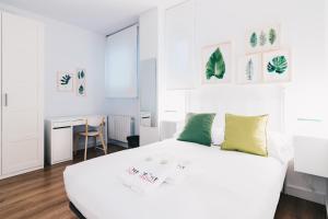 ビルバオにあるBilbao Home Apartment by People Rentalsの白いベッドルーム(ベッド1台、デスク付)