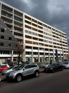 a parking lot with cars parked in front of a large building at Uniclub House in Cosenza