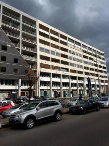 un parking avec des voitures garées devant un grand bâtiment dans l'établissement Uniclub House, à Cosenza