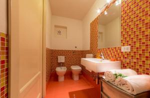 a bathroom with a white sink and a toilet at Casa Scilocco in San Vito lo Capo