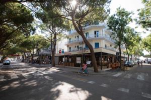 une personne circulant à vélo dans une rue avec un bâtiment dans l'établissement Hotel Danieli, à Lido di Jesolo