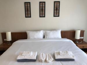 a white bed with two towels on top of it at Crystal Lamai Hotel in Lamai