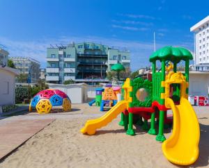 un parque infantil con un colorido equipo de juegos en la arena en Hotel Executive La Fiorita, en Rímini