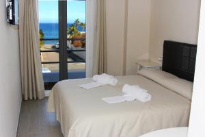 a hotel room with two beds and a view of the ocean at H Rincón de Diego in Mojácar