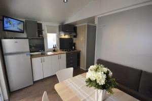 a kitchen with a table with a vase of flowers on it at Topcamp in Union Lido in Cavallino-Treporti