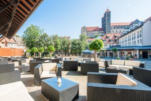 un patio con sillas, mesas y edificios en Best Western Hotel Schlossmühle Quedlinburg, en Quedlinburg