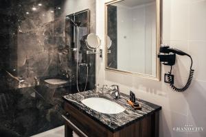 a bathroom with a sink and a shower at Hotel Grand City Wrocław in Wrocław