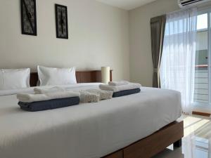 a bedroom with a large white bed with towels on it at Crystal Lamai Hotel in Lamai