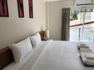 a white bed with two towels on top of it at Crystal Lamai Hotel in Lamai