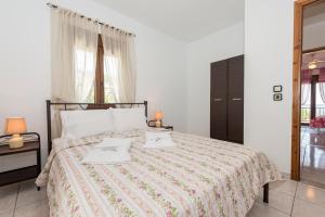 a bedroom with a bed with two towels on it at Maria's House in Potamiá