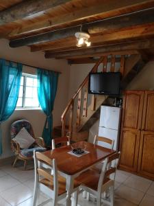 une salle à manger avec une table et une télévision dans l'établissement Kassiesbaai Cottage, à Arniston