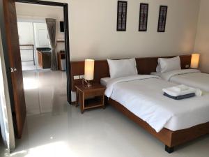a bedroom with two beds and a lamp and a mirror at Crystal Lamai Hotel in Lamai