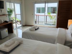 a hotel room with two beds and a balcony at Crystal Lamai Hotel in Lamai