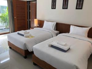 two beds in a hotel room with towels on them at Crystal Lamai Hotel in Lamai