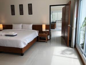 a bedroom with a bed and a door to a bathroom at Crystal Lamai Hotel in Lamai