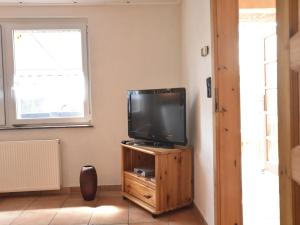 un televisor sentado en un soporte de madera en una habitación en Modern Holiday Home in Graal-Muritz Germany with Garden, en Graal-Müritz
