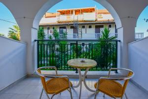 d'une table et de chaises sur un balcon avec vue sur un bâtiment. dans l'établissement Villa Phoenix, à Laganas