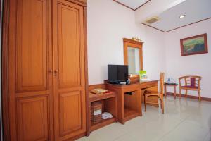 a room with a desk with a television and a cabinet at Sapta Nawa Resort 1 Gresik in Gresik