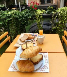 stół z dwoma talerzami chleba i filiżanką kawy w obiekcie Les Suites de Vanves - Parc des expositions Porte de Versailles w mieście Vanves