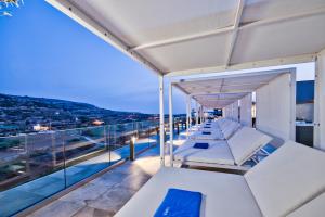 a row of white tables on the balcony of a building at Luna Holiday Complex in Mellieħa