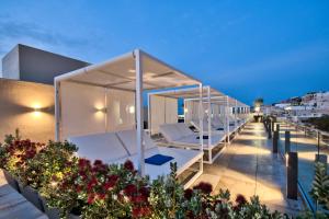 a rooftop deck with lounge chairs on a building at Luna Holiday Complex in Mellieħa