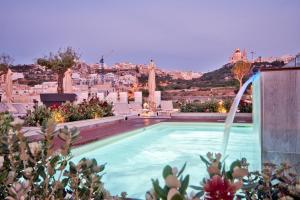 a swimming pool with a view of a city at Luna Holiday Complex in Mellieħa