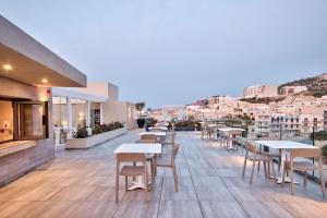 a restaurant with tables and chairs on a balcony at Luna Holiday Complex in Mellieħa