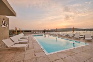 a swimming pool with lounge chairs and a resort at Luna Holiday Complex in Mellieħa