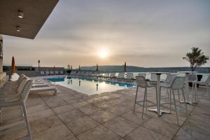 a view of a pool with chairs and a table at Luna Holiday Complex in Mellieħa
