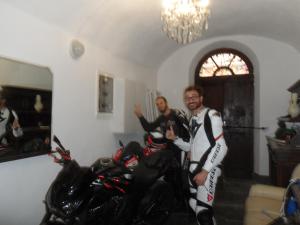 two men standing in a room next to motorcycles at B&B Palazzo Barli in Pieve di Teco