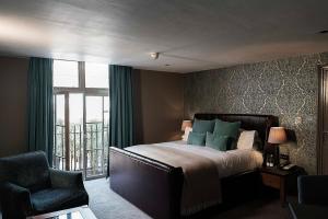 een slaapkamer met een bed, een stoel en een raam bij Hotel du Vin & Bistro Cambridge in Cambridge