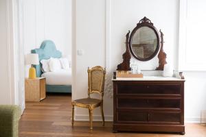 1869 Príncipe Real House في لشبونة: غرفة نوم مع خزانة مع مرآة وسرير