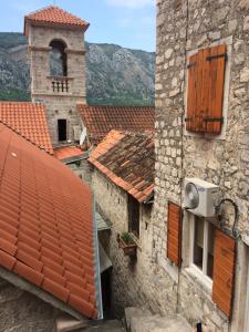 an overhead view of roofs of buildings with a clock tower at Chic & Stylish with Seaview-Terrace - Kotor Indah in Kotor