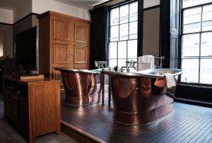 een badkamer met 2 koperen baden in een kamer bij Hotel du Vin & Bistro Cambridge in Cambridge