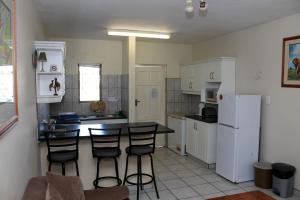 a kitchen with a table and chairs and a refrigerator at 62 The Bridge Holiday Resort in St Lucia