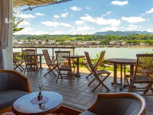 d'une terrasse avec tables et chaises et vue sur la rivière. dans l'établissement Hita Onsen Kizantei Hotel, à Hita