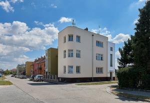 a white building with a cross on top of it at Penzion Karolinka in Kroměříž