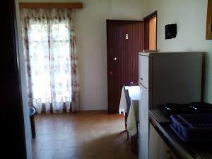 a kitchen with a refrigerator and a table and a window at Nikolas Apartments in Kato Daratso