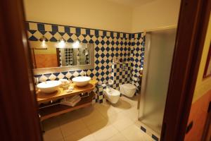 ein Badezimmer mit zwei Waschbecken und einem WC in der Unterkunft Felicin - Ristorante Albergo "Dimora Storica" in Monforte dʼAlba