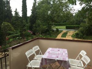 a table and chairs on a balcony with a garden at Magnólia Apartman in Sárvár