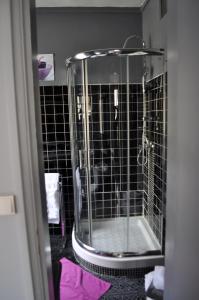 a shower in a bathroom with black tile at La Maison de Jeanne in Dieppe +34 photos