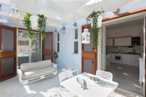 een woonkamer met een witte tafel en stoelen bij A'NACA HOLIDAY HOME in Marina di Ragusa