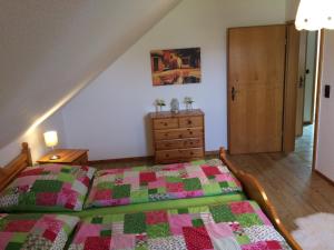 a bedroom with a bed with a green and pink quilt at Ferienwohnung Niederrhein-Oase in Kevelaer