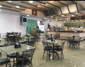 a restaurant with tables and chairs and a counter at Hotel Peroza Corbelia in Corbélia